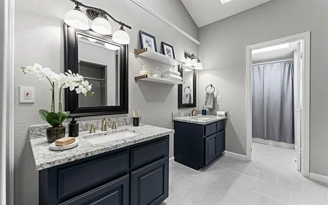 a bathroom with a granite countertop sink a large mirror and a shower