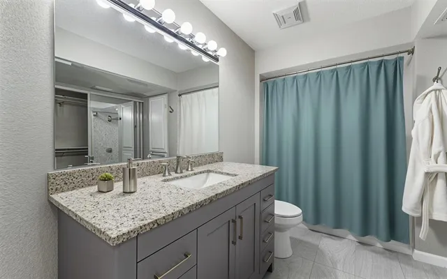 a bathroom with a granite countertop sink and a mirror