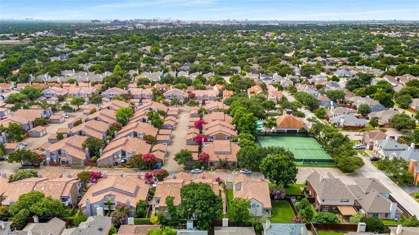 an aerial view of residential houses with outdoor space and trees