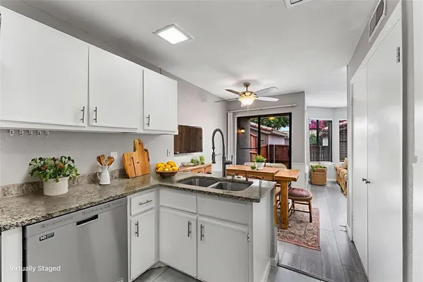 a kitchen with stainless steel appliances granite countertop a sink dishwasher and cabinets with wooden floor