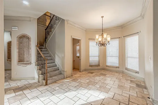 a view of a hallway with windows and chandelier