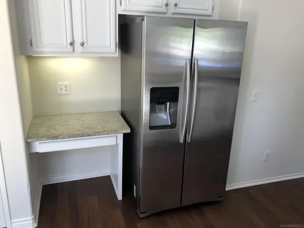 a kitchen with granite countertop a refrigerator and a sink
