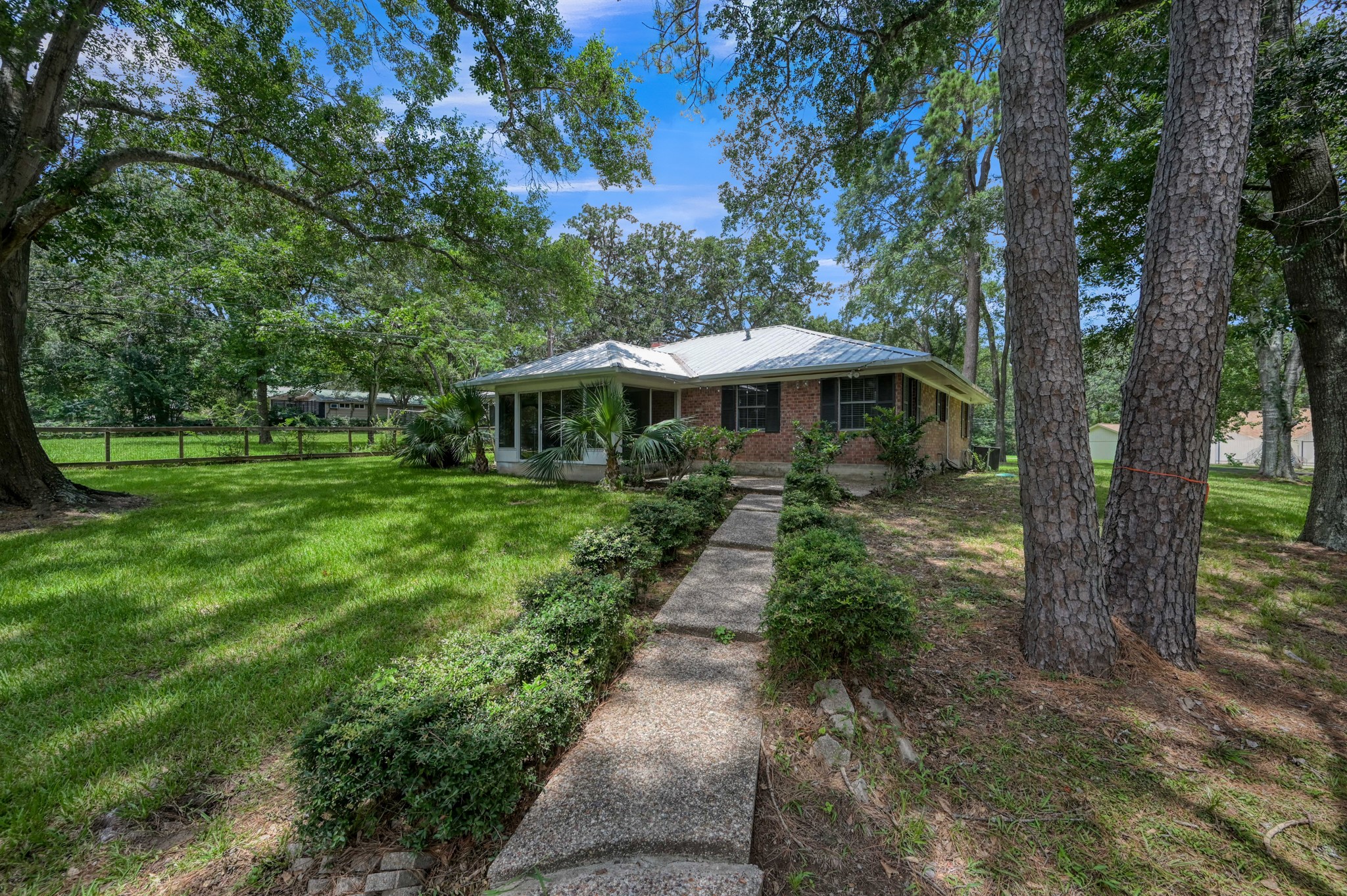 13544 Northshore Loop Conroe, TX 77304 - Photo 5 of 34 The back of the home opens toward the lake, offering a peaceful view and easy outdoor enjoyment. A bright sunroom is attached, providing the perfect spot to relax and take in the scenery year-round.