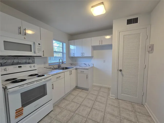 a kitchen with cabinets appliances and a window