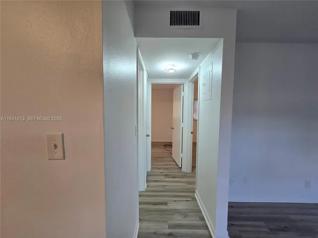 a view of a hallway with wooden floor