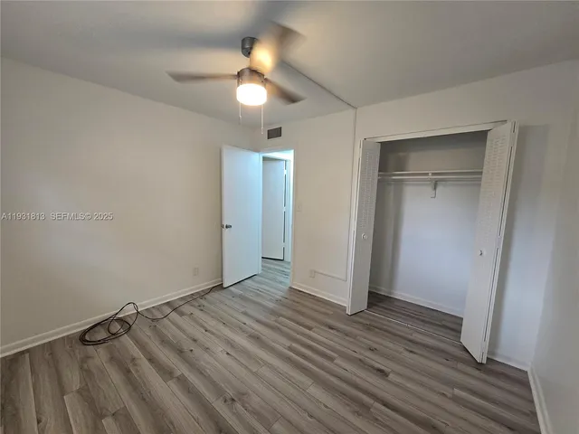 an empty room with closet and wooden floor