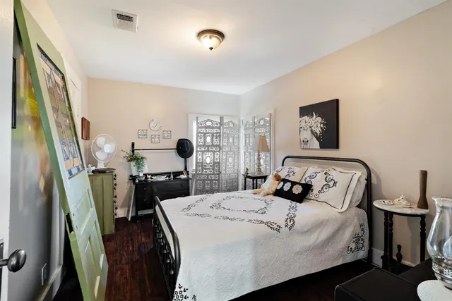 a bedroom with a bed and a flat tv screen on the dresser