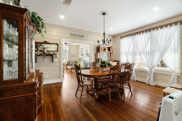 a view of a dining room and livingroom with furniture wooden floor a chandelier