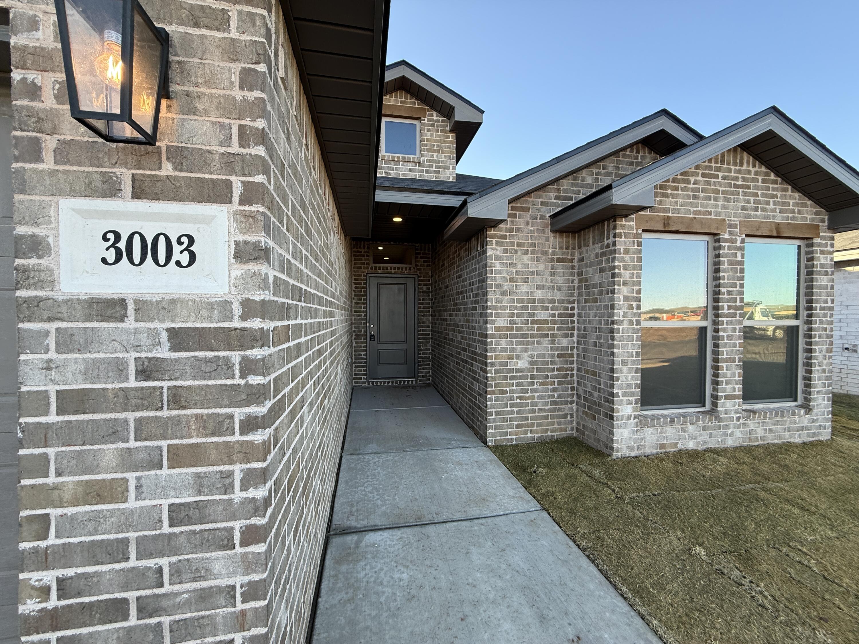 3003 138th Place Lubbock, TX 79423 - Photo 2 of 14 a view of a brick house with large windows