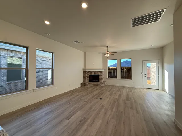 an empty room with wooden floor and fireplace