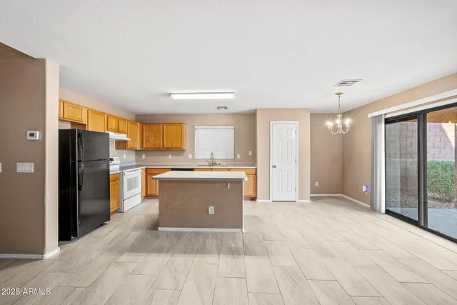 a large kitchen with a refrigerator and a stove top oven