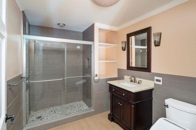 a bathroom with a sink vanity mirror and toilet