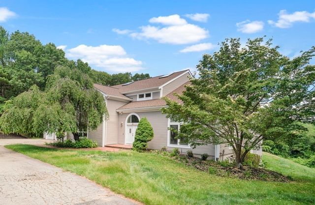 a view of a house with backyard and a tree
