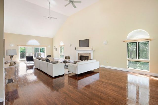 a living room with fireplace furniture and a large window