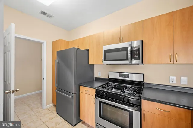 a kitchen with stainless steel appliances granite countertop a refrigerator stove and microwave