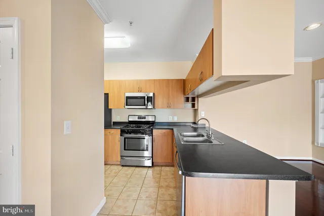 a kitchen with a sink a stove top oven and cabinetry