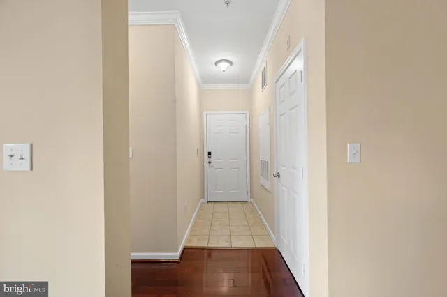 a view of a hallway with wooden floor and a bathroom