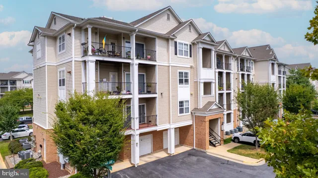 a view of a white building among the street with potted plants