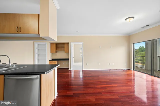 a kitchen with stainless steel appliances granite countertop a sink a stove and a wooden floors