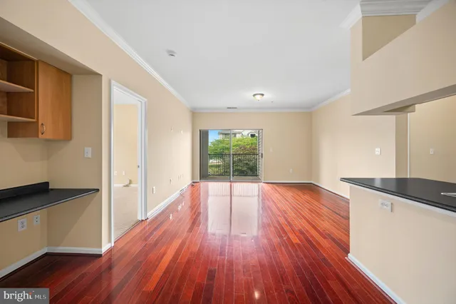 a view of a room with wooden floor and electronic appliances