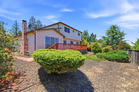 an aerial view of a houses with outdoor space and trees all around
