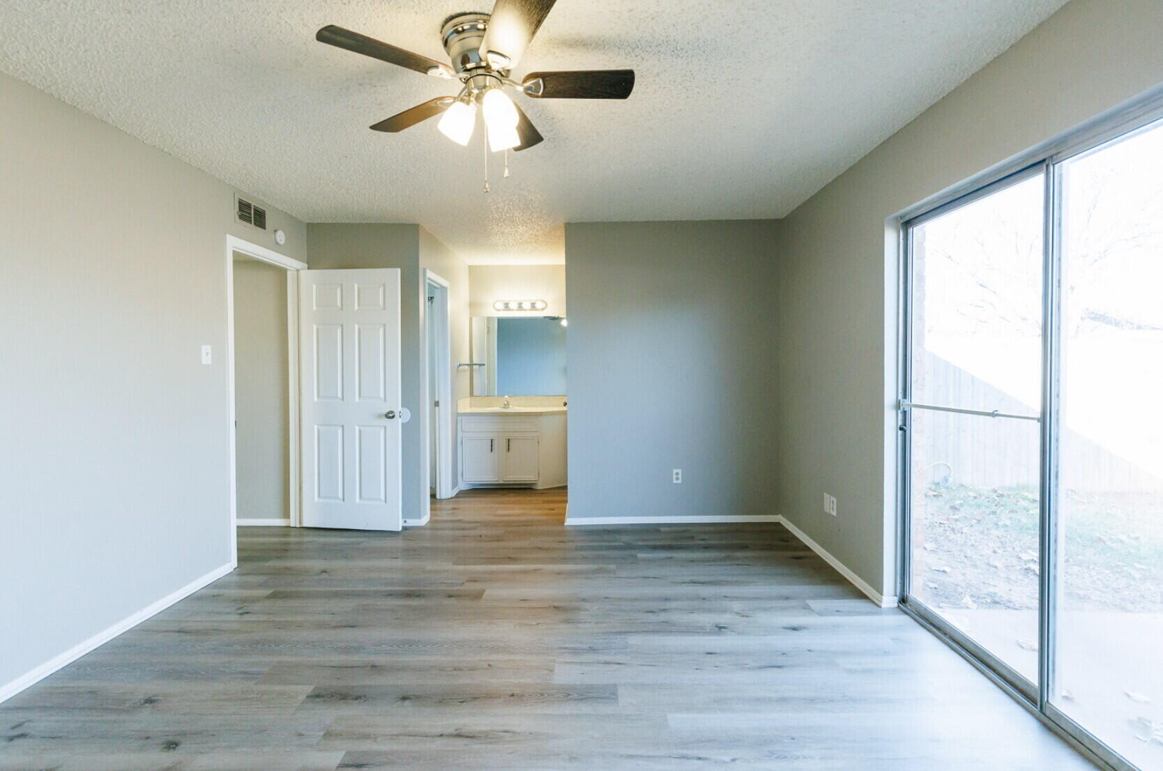 6112 38th Street, Unit A Lubbock, TX 79407 - Photo 14 of 15 a view of empty room with wooden floor and fan