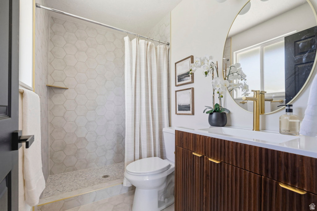 2460 Allison Way Syracuse, UT 84075 - Photo 15 of 24 Bathroom featuring a fluted wood vanity with gold-tone hardware, a circular mirror, and a gold-tone faucet