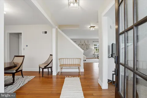 a view of a hallway with wooden floor and windows