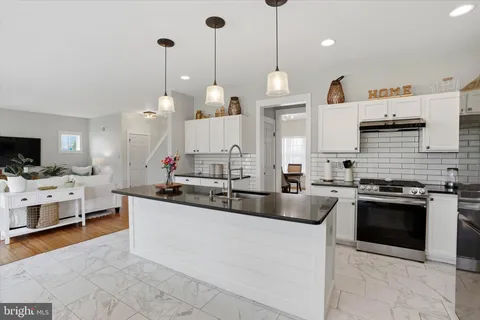 a kitchen with stainless steel appliances granite countertop a sink and a refrigerator
