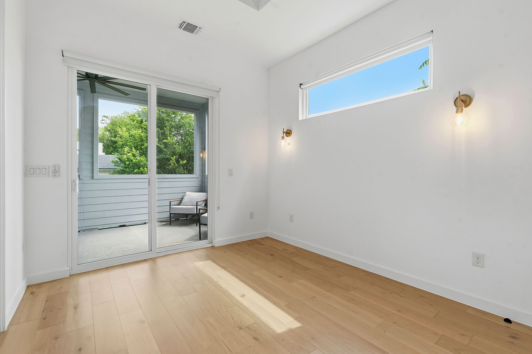 1707 Deloney Street, Unit 2 Austin, TX 78721 - Photo 14 of 26 Hardwood floors and a wide slider lead to a private outdoor balcony, extending this versatile room's living space.
