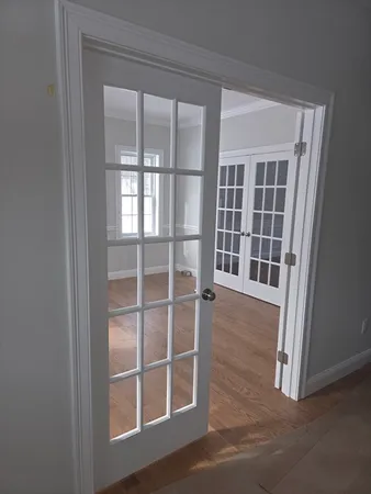 a view of an empty room with wooden floor and windows