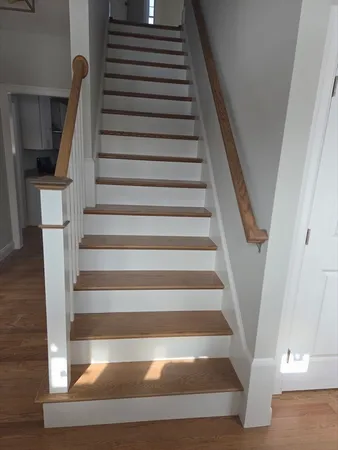 a view of a hallway with wooden floor and staircase
