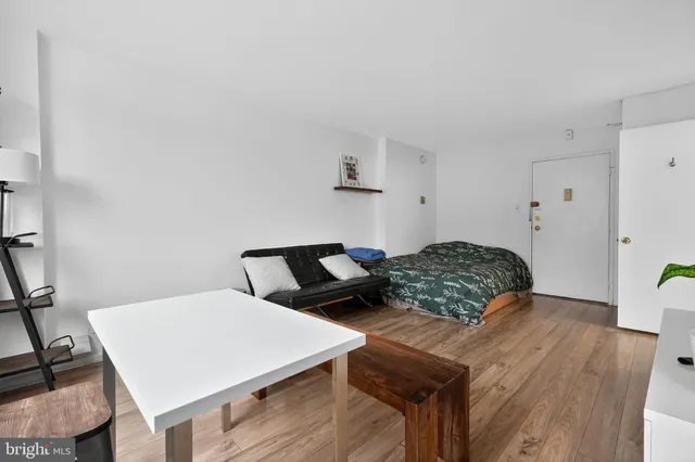 a bedroom with a bed and wooden floor