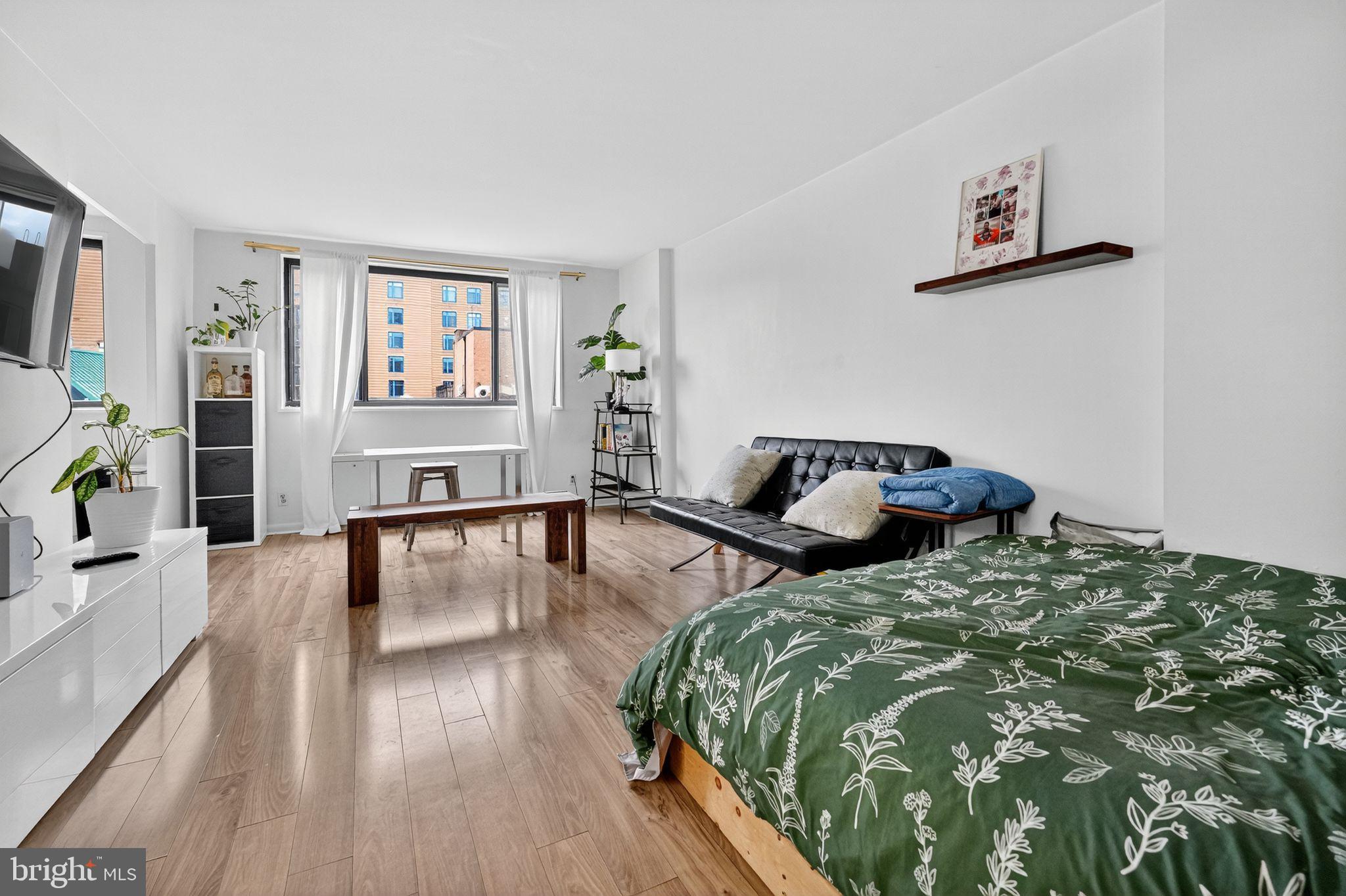 1420 N Street Northwest, Unit 1013 Washington, DC 20005 - Photo 5 of 27 a bedroom with a bed and wooden floor
