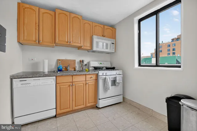 a kitchen with granite countertop white cabinets stainless steel appliances and sink