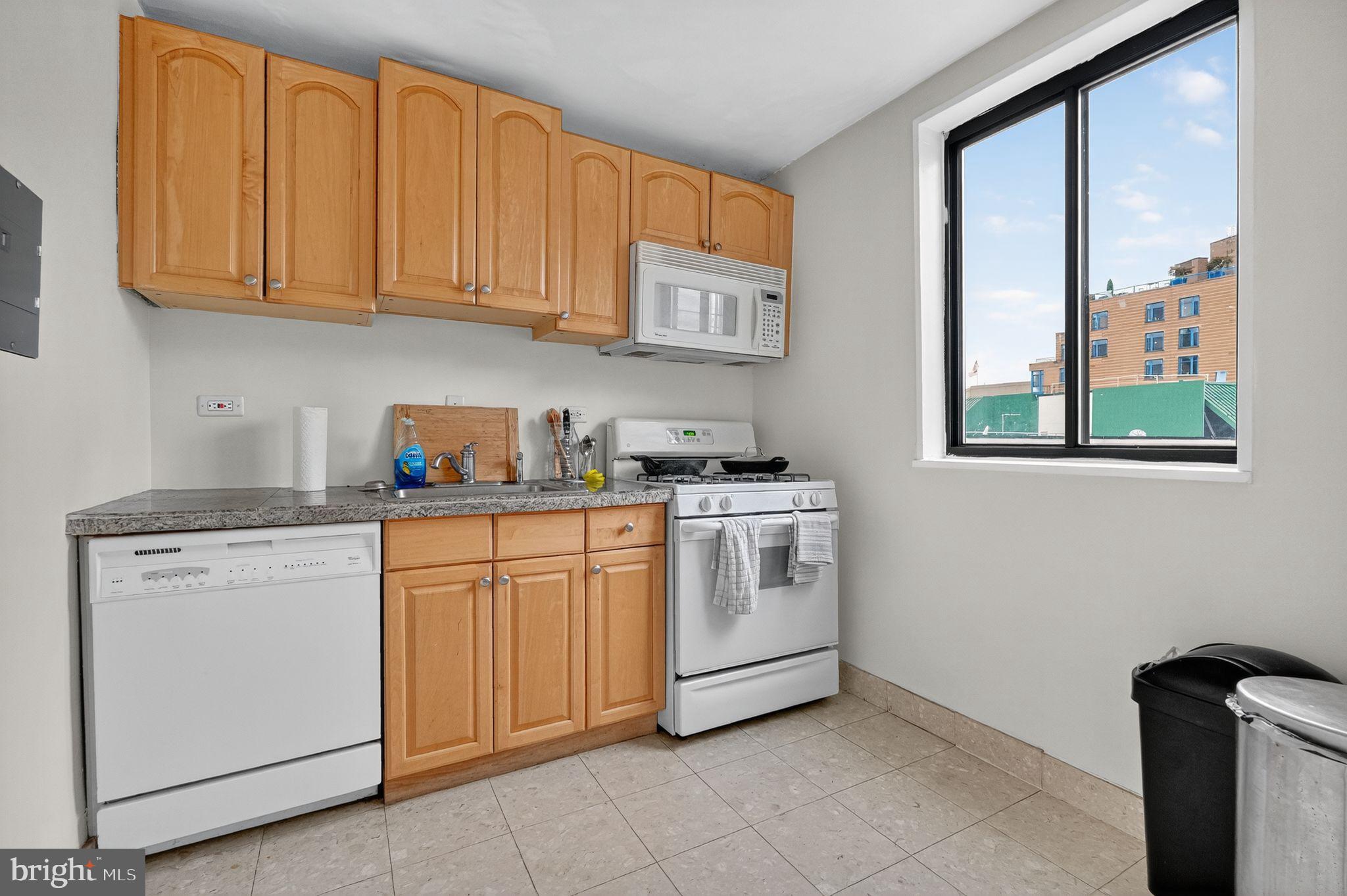 1420 N Street Northwest, Unit 1013 Washington, DC 20005 - Photo 6 of 27 a kitchen with granite countertop white cabinets stainless steel appliances and sink