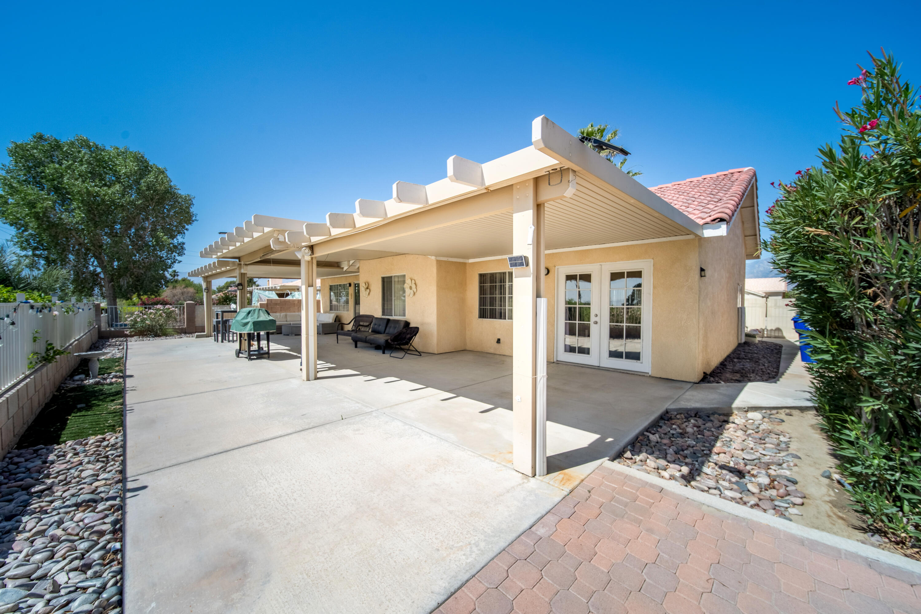 33860 Bell Road Thousand Palms, CA 92276 - Photo 29 of 56 a view of a white house with a small yard and large trees