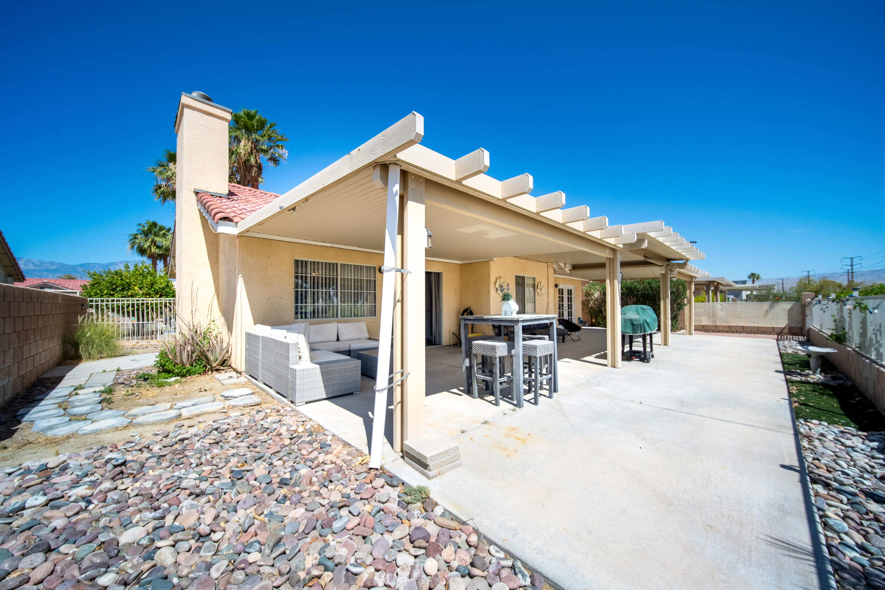 33860 Bell Road Thousand Palms, CA 92276 - Photo 35 of 56 a view of a house with wooden deck and furniture