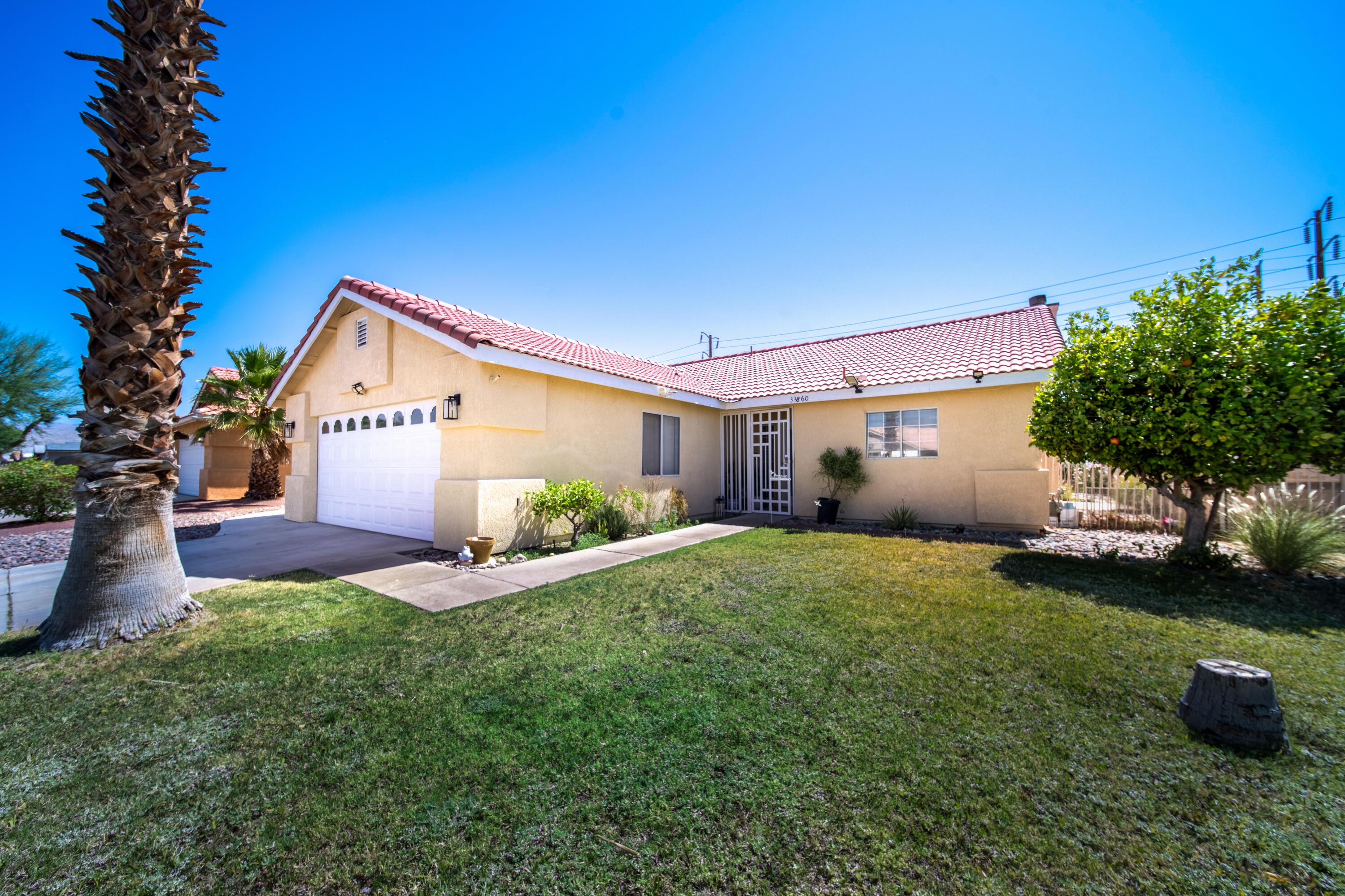 33860 Bell Road Thousand Palms, CA 92276 - Photo 41 of 56 a front view of a house with a yard and garage