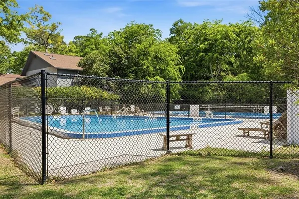 a swimming pool with trees in the background