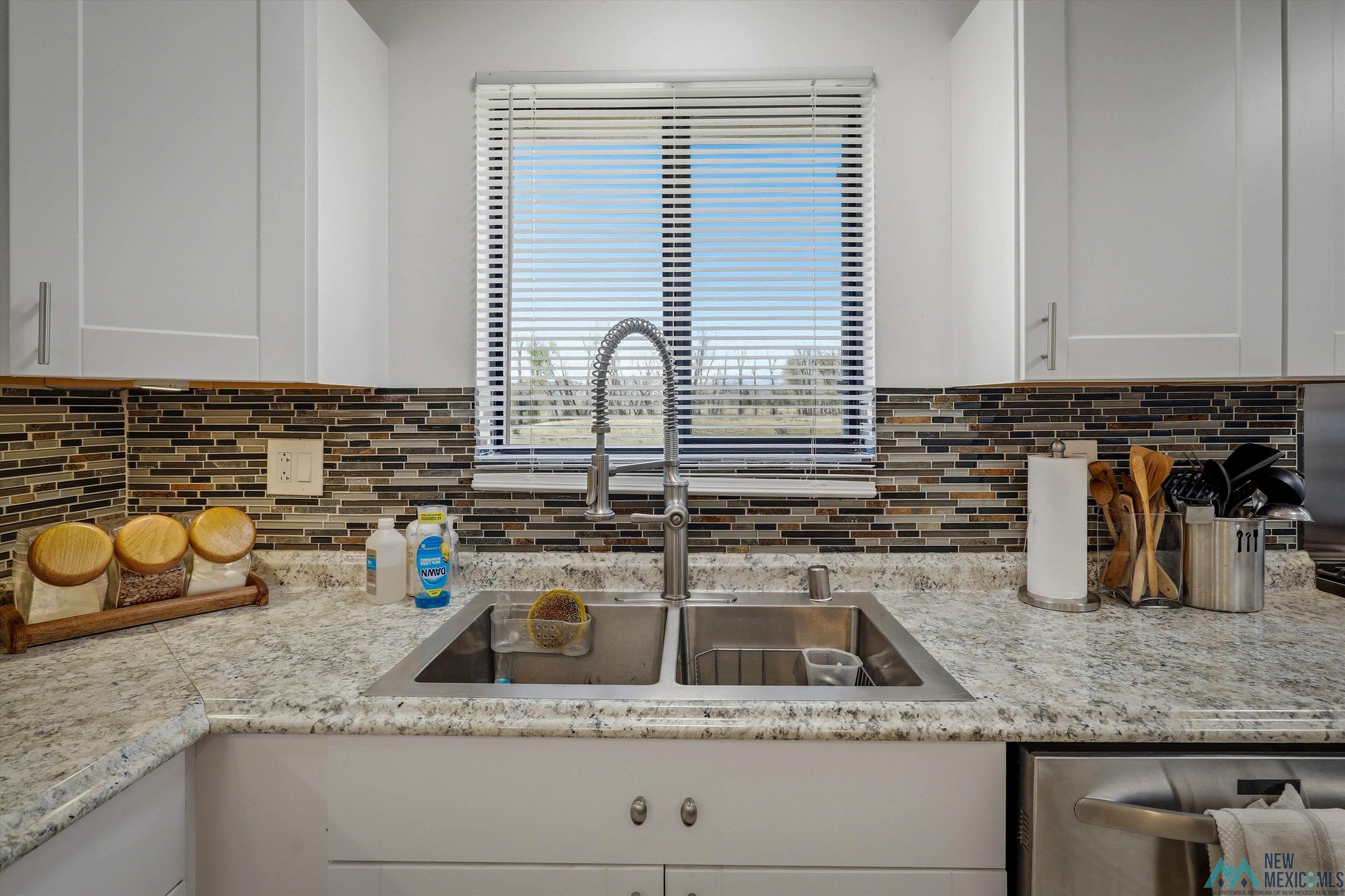 83 Juniper Road Chama, NM 87520 - Photo 10 of 56 Kitchen sink area featuring a dual basin stainless steel sink with a high-arch faucet, set in a light-toned speckled countertop
