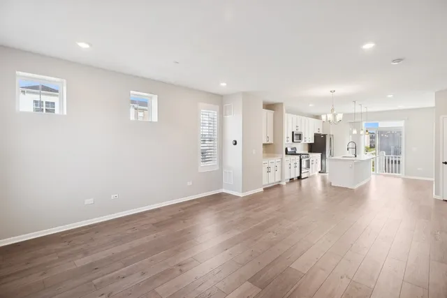 a view of a kitchen with wooden floor and a window