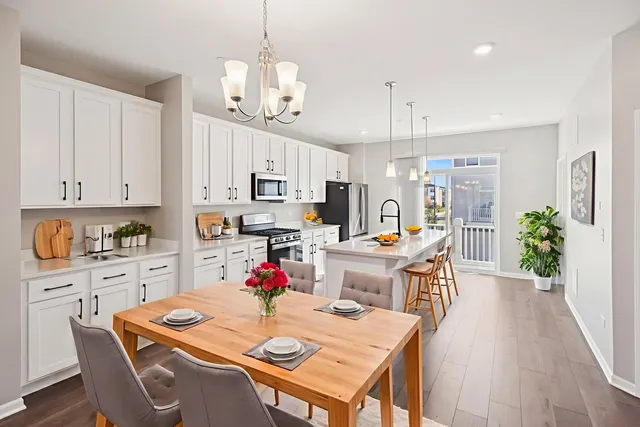 a open dining room with stainless steel appliances kitchen island granite countertop a dining table chairs and kitchen view