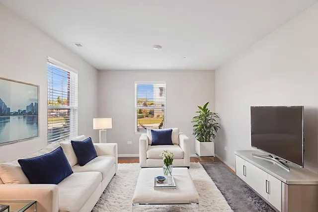 a living room with furniture a flat screen tv and a large window
