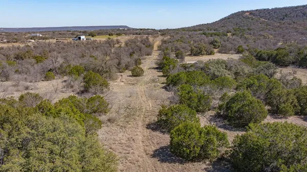 an aerial view of residential houses with outdoor space and trees