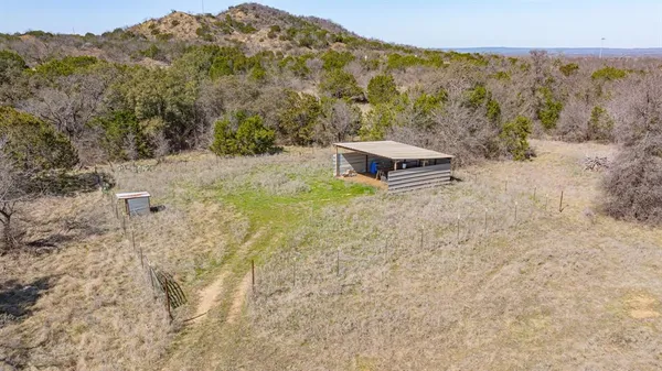 a view of a dry yard with mountains in the background