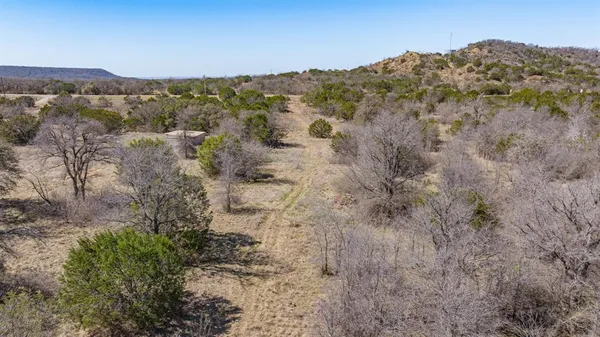a view of a dry yard with mountains in the background