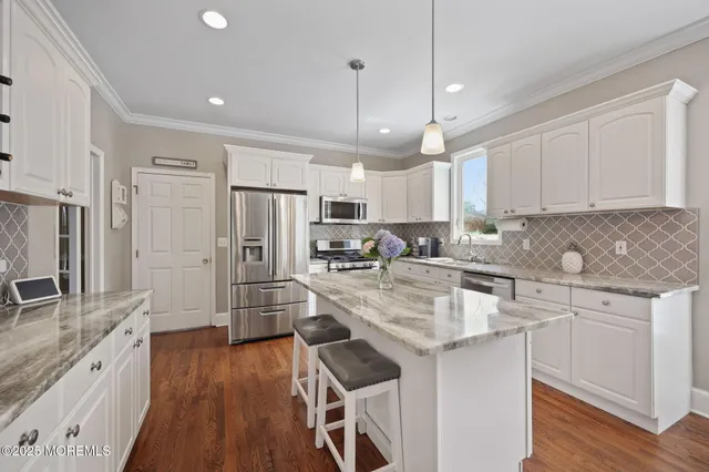 a kitchen with stainless steel appliances granite countertop a stove a sink and a microwave