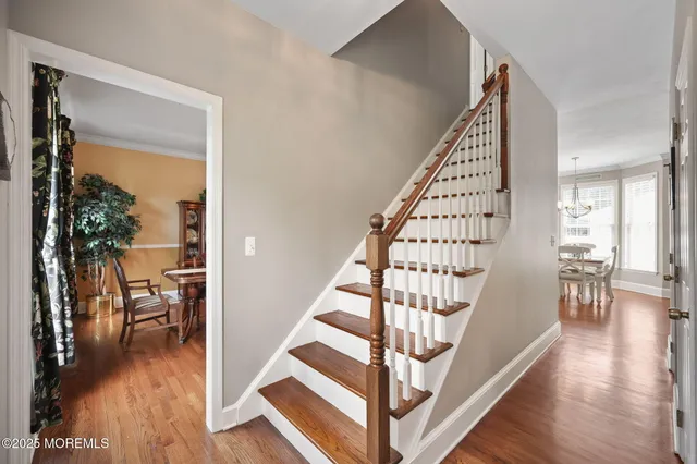a view of staircase with lots of frames on wall and a window