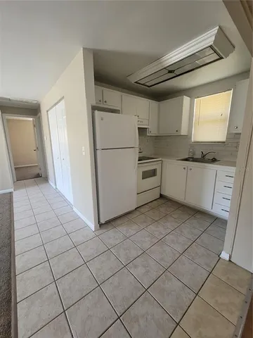 a kitchen with a cabinets and white appliances